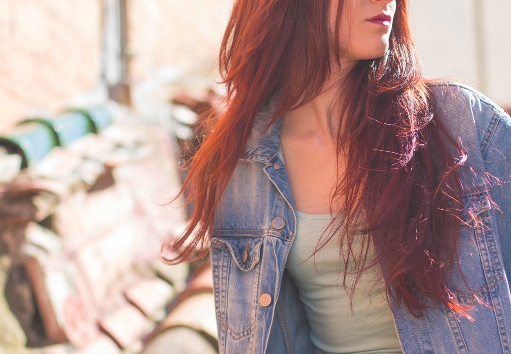 Frau mit langen roten Haaren und Jeansjacke