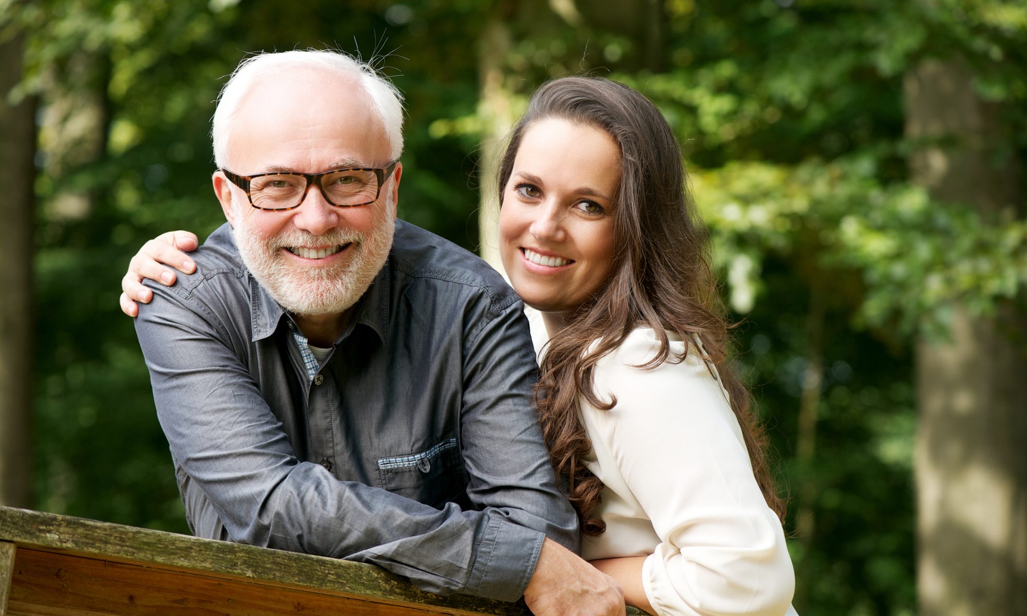 Reifer grauhaariger Herr mit junger Freundin