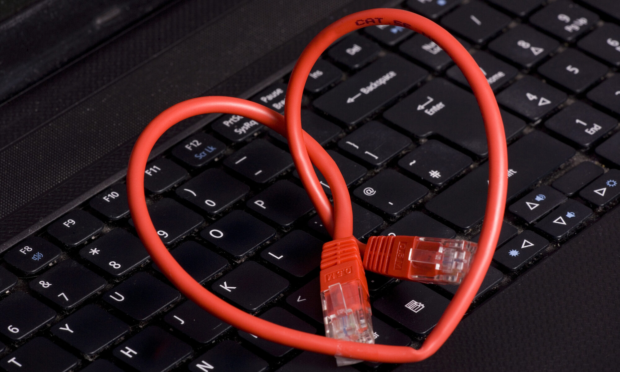 Kabel liegt als Herz auf der Tastatur