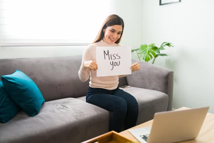 Frau hält Schild mit "miss You" hoch