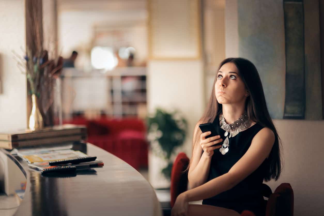 Frau mit Smartphone möchte Ihr Date absagen