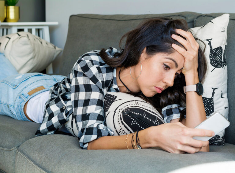 Online-Dating-Burnout - Frau liegt genervt auf dem Sofa